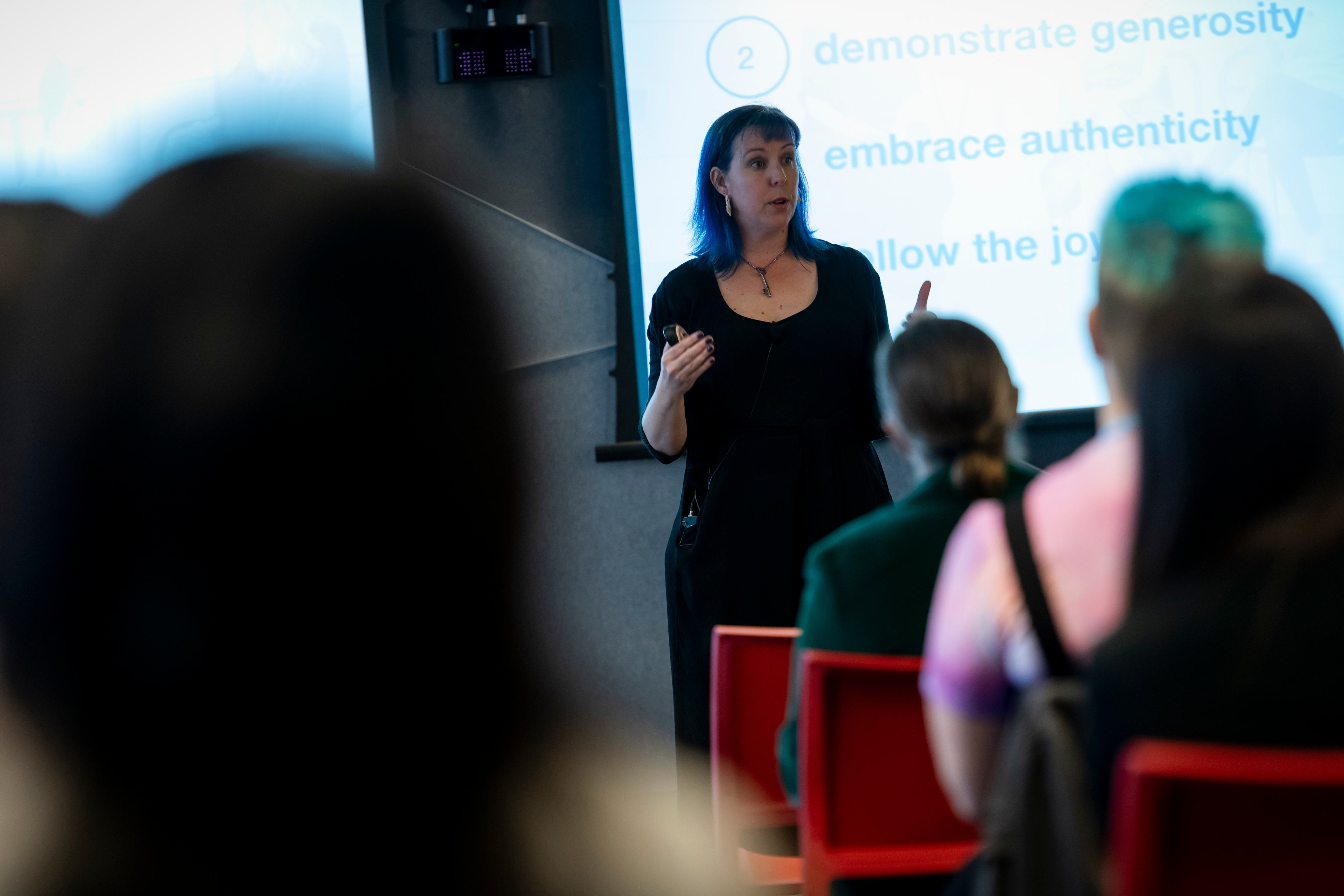Kimberly in front of a room teaching, audience blurred