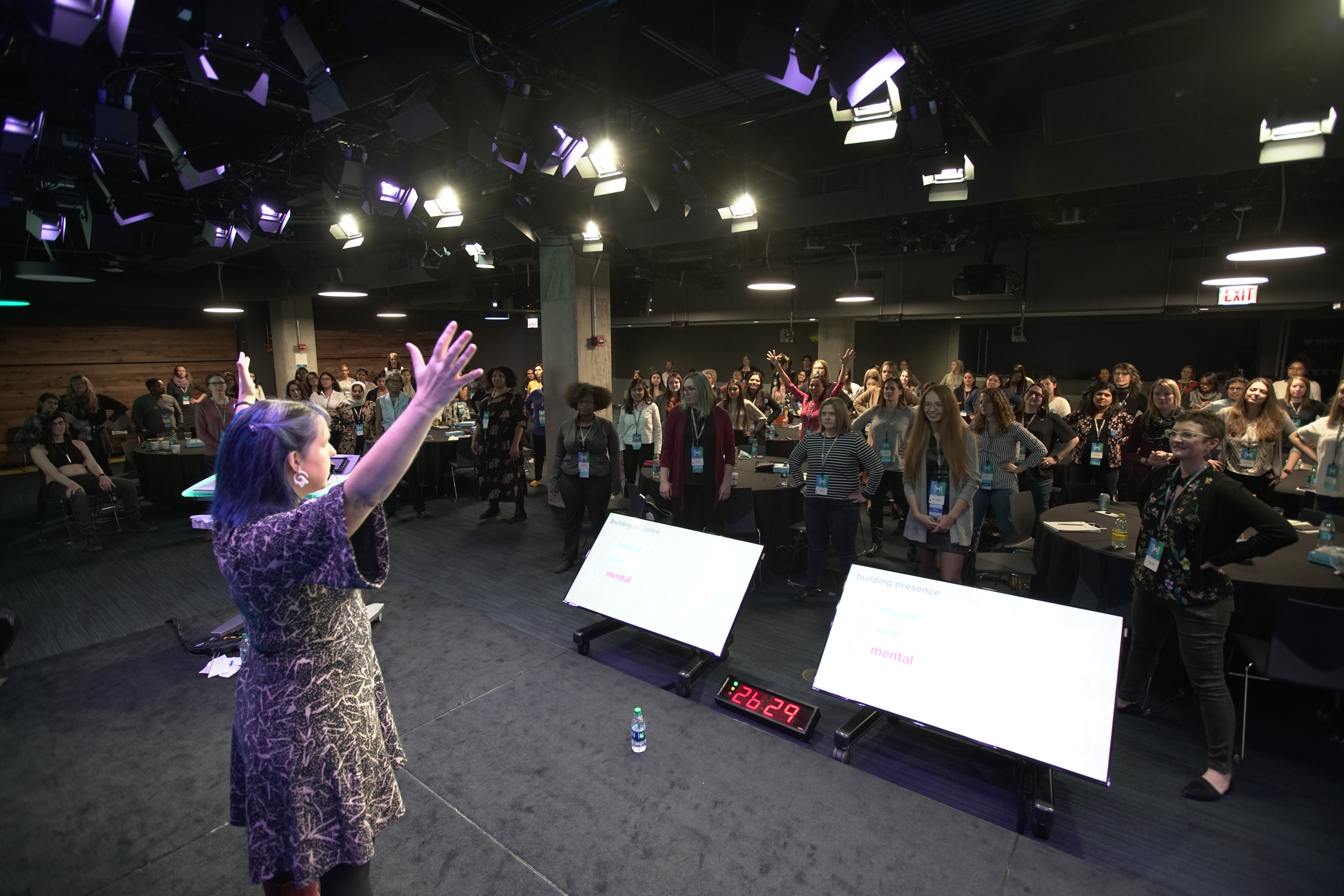 Kimberly in front a room of 100s teaching folks to take up space